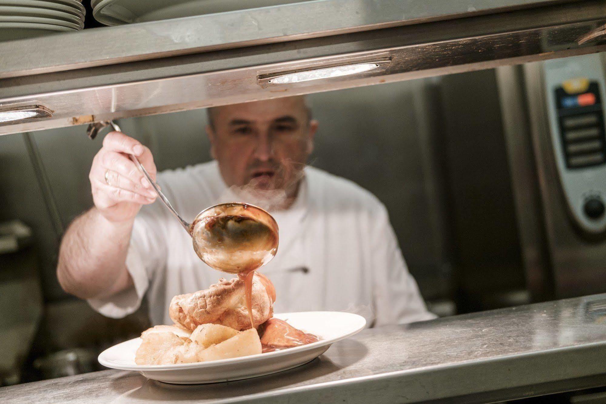 富勒汉普郡酒店 Clanfield  外观 照片 A chef preparing a meal
